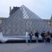 A wedding couple hugs as visitors queue to enter the Louvre museum three days after historic jewels were stolen in a daring daylight heist, on October 22, in Paris. Photo: AP Photo