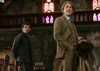From left to right: Josh O'Connor leaning against a church bench and Daniel Craig holding a coat and hat as Benoit Blanc in Wake Up Dead Man.