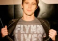 Sam opens jacket to reveal "Flynn Lives" shirt in "Tron: The Next Day" (2011)
