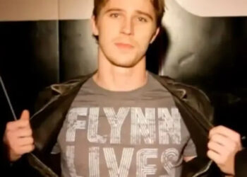 Sam opens jacket to reveal "Flynn Lives" shirt in "Tron: The Next Day" (2011)