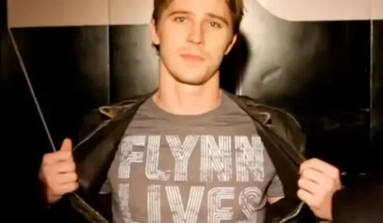 Sam opens jacket to reveal "Flynn Lives" shirt in "Tron: The Next Day" (2011)