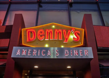 A neon Denny's sign at night