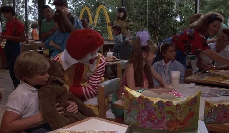 Ronald McDoland and Eric wheeling up to a table in Mac and Me