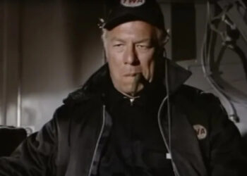 George Kennedy's Joe Petroni looking serious and smoking a cigar in Airport