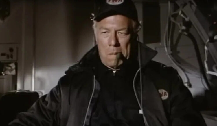 George Kennedy's Joe Petroni looking serious and smoking a cigar in Airport