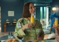 Molly holding a mimosa and talking to Nicholas on Loot