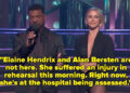 Two hosts on a stage with performers in the background. The male host wears a dark suit, and the female host is in a sleek, form-fitting outfit