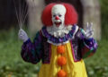 Pennywise cackling and holding balloons in It