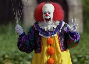 Pennywise cackling and holding balloons in It