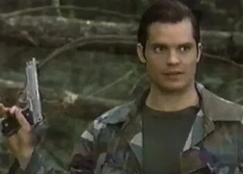 Scooby holding a gun in the woods in Mr. & Mrs. Smith