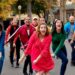 Rachel Bloom sings and dances down the street in unison with a large group in "Crazy Ex-Girlfriend."