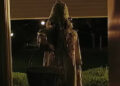 Creepy ghost woman holding basket in doorway in V/H/S/Halloween.