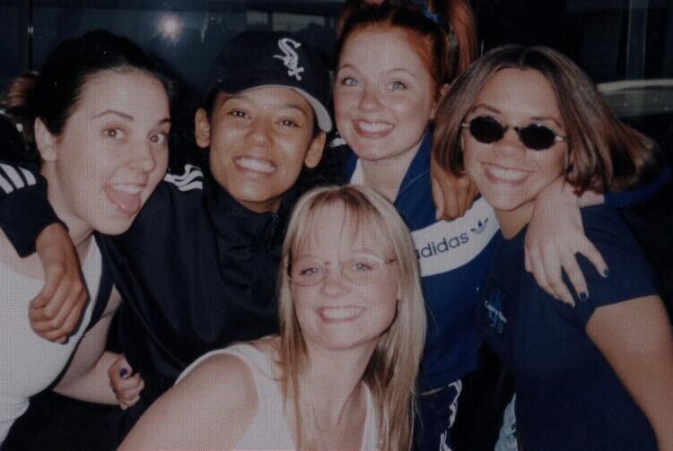 Spice Girls Melanie Chisholm, Melanie Brown, Emma Bunton, Geri Halliwell and Victoria Beckham smile.