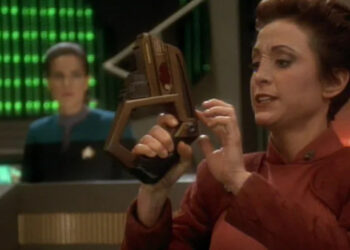 Kira holding a phaser with Dax in the background on Star Trek: Deep Space Nine