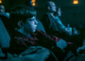 Miles Ekhardt's Matty sitting in a movie theater in It: Welcome to Derry