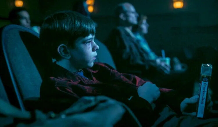 Miles Ekhardt's Matty sitting in a movie theater in It: Welcome to Derry