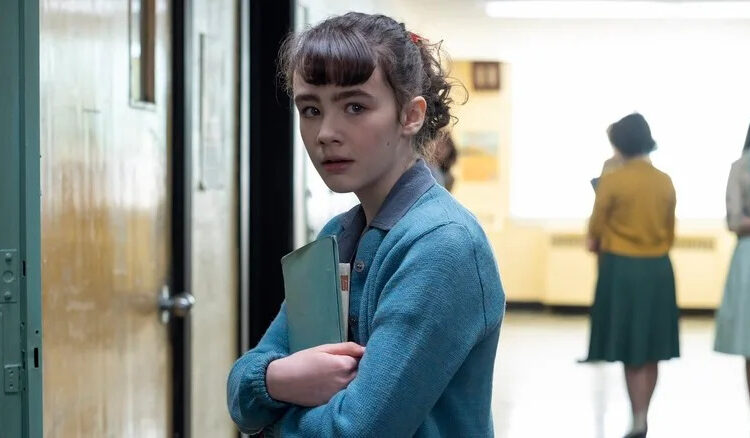 Clara Stack as Lily holding books in school in It: Welcome to Derry episode 1