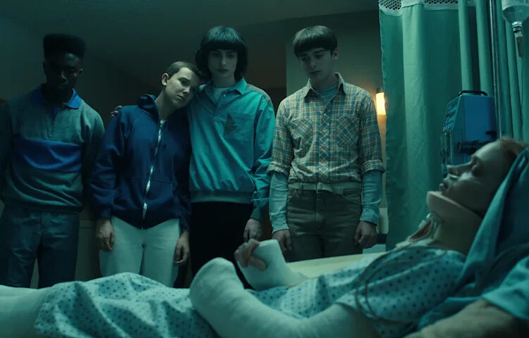 A still, showing Max in a coma surrounded by the others, from Season 4 of 'Stranger Things.'