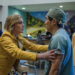 Rhea Seehorn as Carol Sturka grabbing a doctor by the shoulders in Pluribus