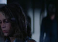 Laurie, tired, with Michael Myers standing behind her in Halloween (1978)