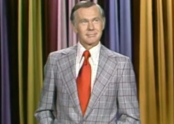 Johnny Carson stands on stage and smiles in The Tonight Show Starring Johnny Carson