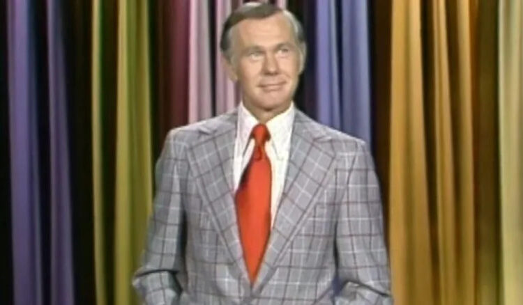 Johnny Carson stands on stage and smiles in The Tonight Show Starring Johnny Carson