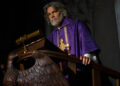 Josh Brolin as Jefferson Wicks standing at a podium in Wake Up Dead Man: A Knives Out Mystery