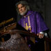 Josh Brolin as Jefferson Wicks standing at a podium in Wake Up Dead Man: A Knives Out Mystery