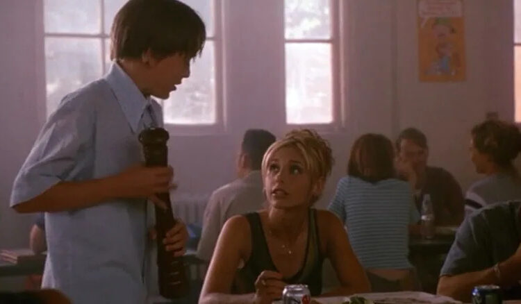 Sarah Michelle Gellar's unnamed character sitting at a cafeteria table in