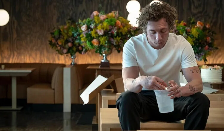 Jeremy Allen White as Carmy holding a cup in The Bear