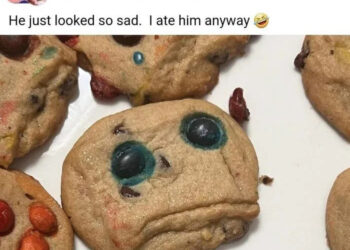 Cookies with candy faces; one has a sad expression. Post text: "He just looked so sad. I ate him anyway" with a laughing emoji