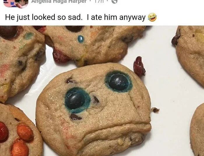 Cookies with candy faces; one has a sad expression. Post text: "He just looked so sad. I ate him anyway" with a laughing emoji