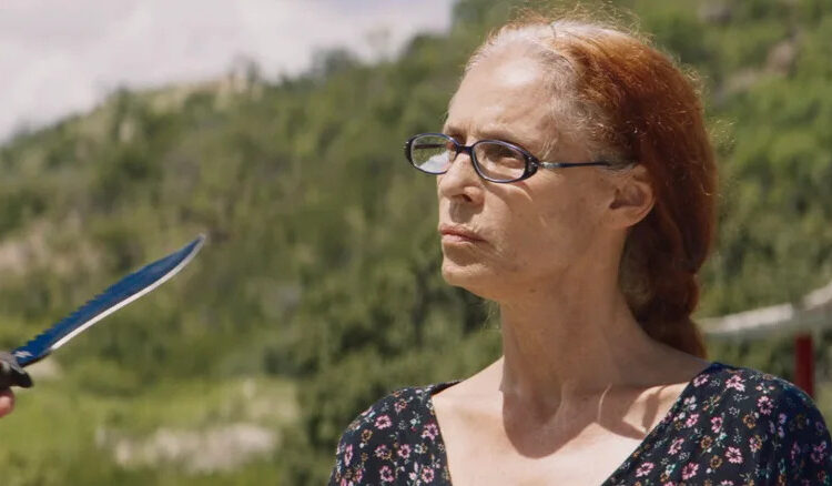 Sônia Braga as Domingas faces a knife held by someone standing off-screen in Bacurau
