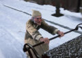 Scrooge riding the back of a carriage in A Christmas Carol (2009)