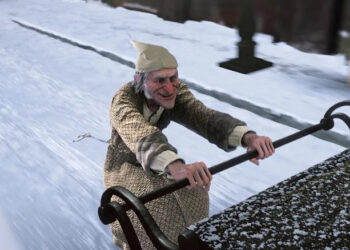 Scrooge riding the back of a carriage in A Christmas Carol (2009)