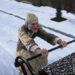 Scrooge riding the back of a carriage in A Christmas Carol (2009)