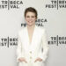 Sophia Lillis smiles in a white suit.