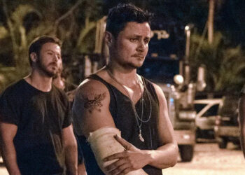 Moe holding his cast with a look of pain in his eyes in Road House