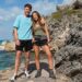 Roman and Harleymoon Kemp wearing shorts and T-shirts, standing on a rock beside the sea.