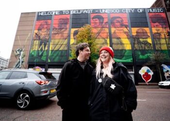 Mural artists Friz (Marian Noone) and Gerry Norman in front of new UNESCO City of Music mural on the Telegraph Building.