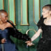 Cynthia Erivo and Ariana Grande holding hands and smiling at each other at a Wicked premiere