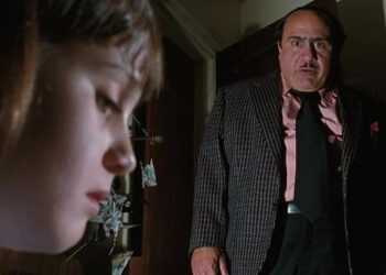 Danny DeVito as Harry Wormwood shoots a sinister stare at Mara Wilson as Matilda Wormwood in Matilda
