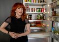Kathy Griffin smiles in front of her neatly stocked fridge.