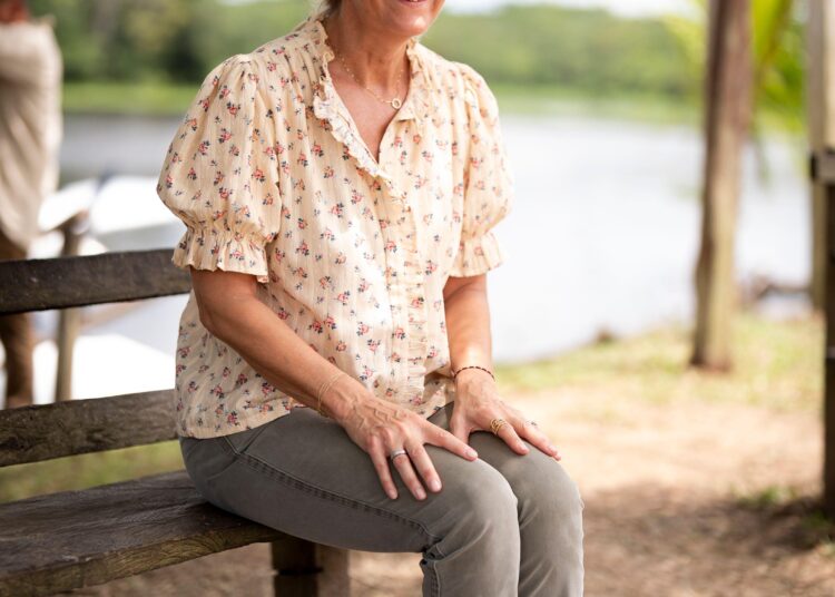 Duchess Sophie sitting on a bench wearing a floral top and gray pants