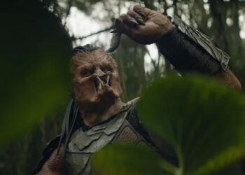 Dek holding up a bug in "Predator: Badlands" (2025)