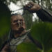 Dek holding up a bug in "Predator: Badlands" (2025)