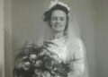 A woman in a white wedding dress holds flowers. It is Hilda Hutton who made munitions in Rotherham during wartime