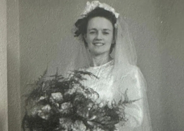 A woman in a white wedding dress holds flowers. It is Hilda Hutton who made munitions in Rotherham during wartime