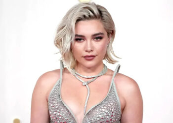 Florence Pugh poses on the red carpet at the 96th Annual Academy Awards in a silver dress.