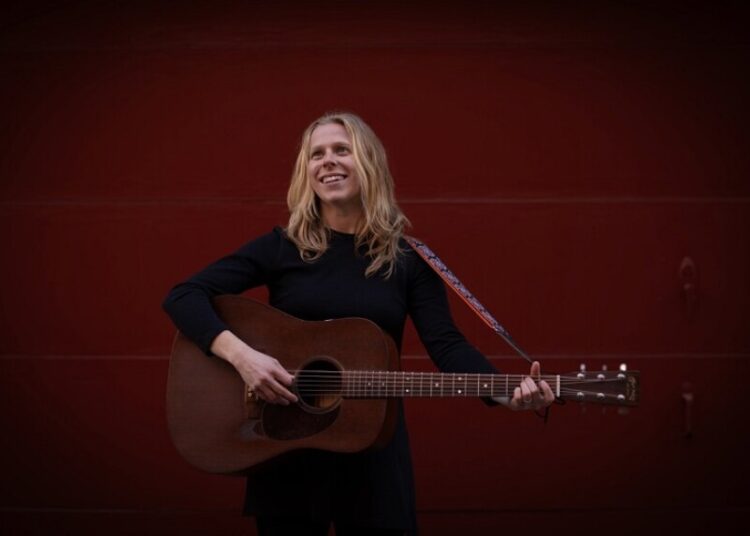 Musciain Jeri Katherine Howell plays acoustic guitar on her new solo album, Woman.